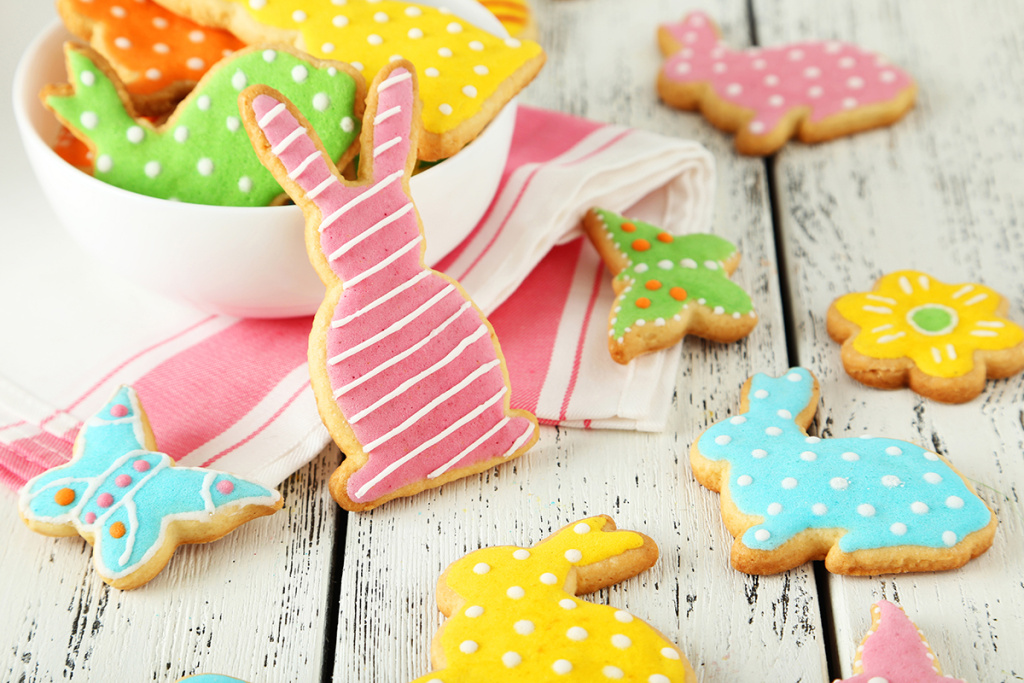 Colorful easter cookies on white wooden background